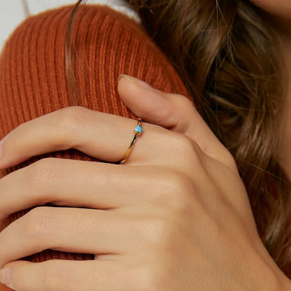 Bague fine plaqué or avec pierre turquoise facettée, au design minimaliste et lumineux, symbole d’élégance délicate et intemporelle.