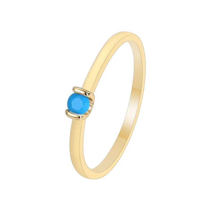 Bague fine plaqué or avec pierre turquoise facettée, au design minimaliste et lumineux, symbole d’élégance délicate et intemporelle.