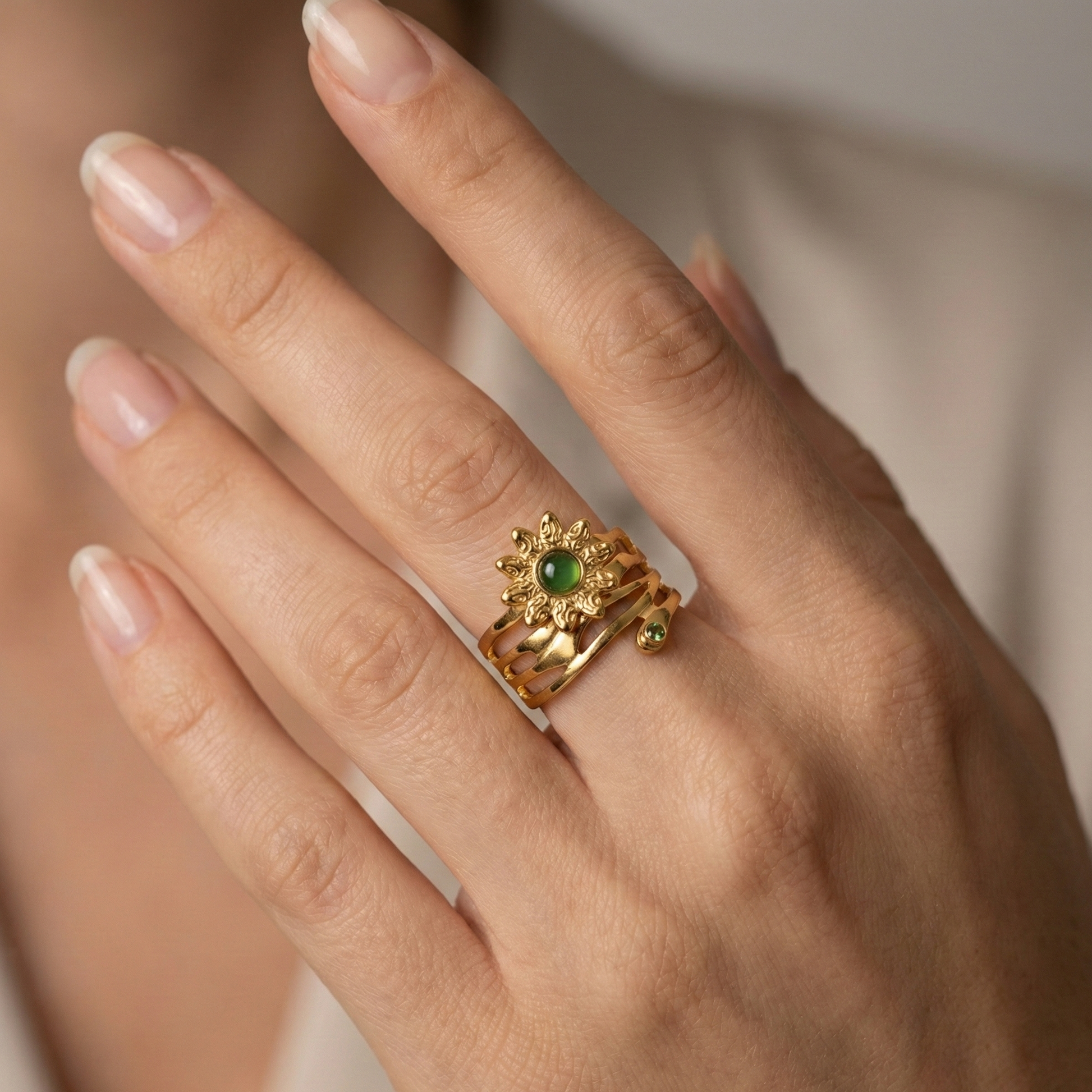 Bague fleur solaire en acier inoxydable doré avec pierre verte lisse et cristaux verts facettés, design organique et symbolique