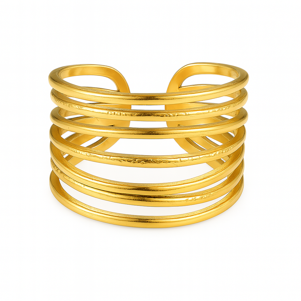 Bague dorée large au design graphique et structuré, cette pièce reproduit l’effet de plusieurs anneaux fins empilés. L’alternance de textures lisses et martelées crée un jeu visuel subtil, à la fois épuré et travaillé. Une bague tendance à fort impact visuel, idéale pour moderniser n’importe quelle tenue.
