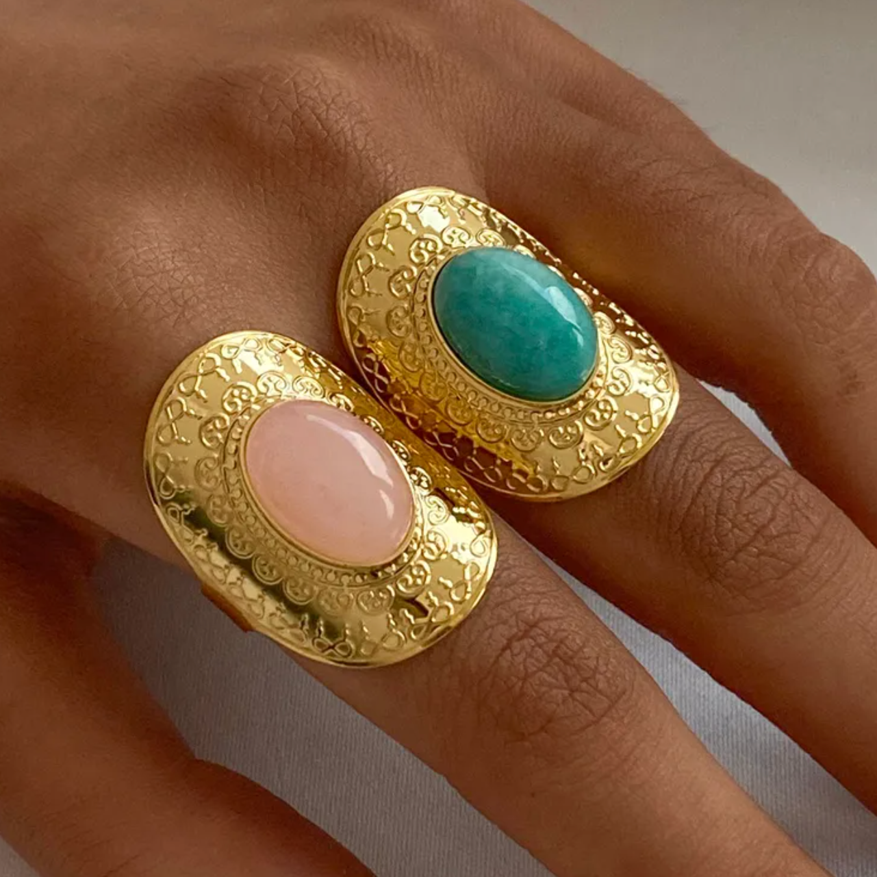 Une bague structurée en acier inoxydable doré, composée de cinq rangs perlés et ornée d’une pierre ronde verte foncée. Son style affirmé et texturé en fait un accessoire de caractère à l’élégance organique.

Matériau : Acier inoxydable couleur doré, placage PVD or 18K, cabochon vert synthétique, hypoallergénique, résistant à l’eau et à l’oxydation.

Dimensions : Diamètre 1,8 cm, taille ajustable, poids 2,1 g.

Design : Structure ouverte, composée de rangées perlées régulières, reliées par un axe central qui