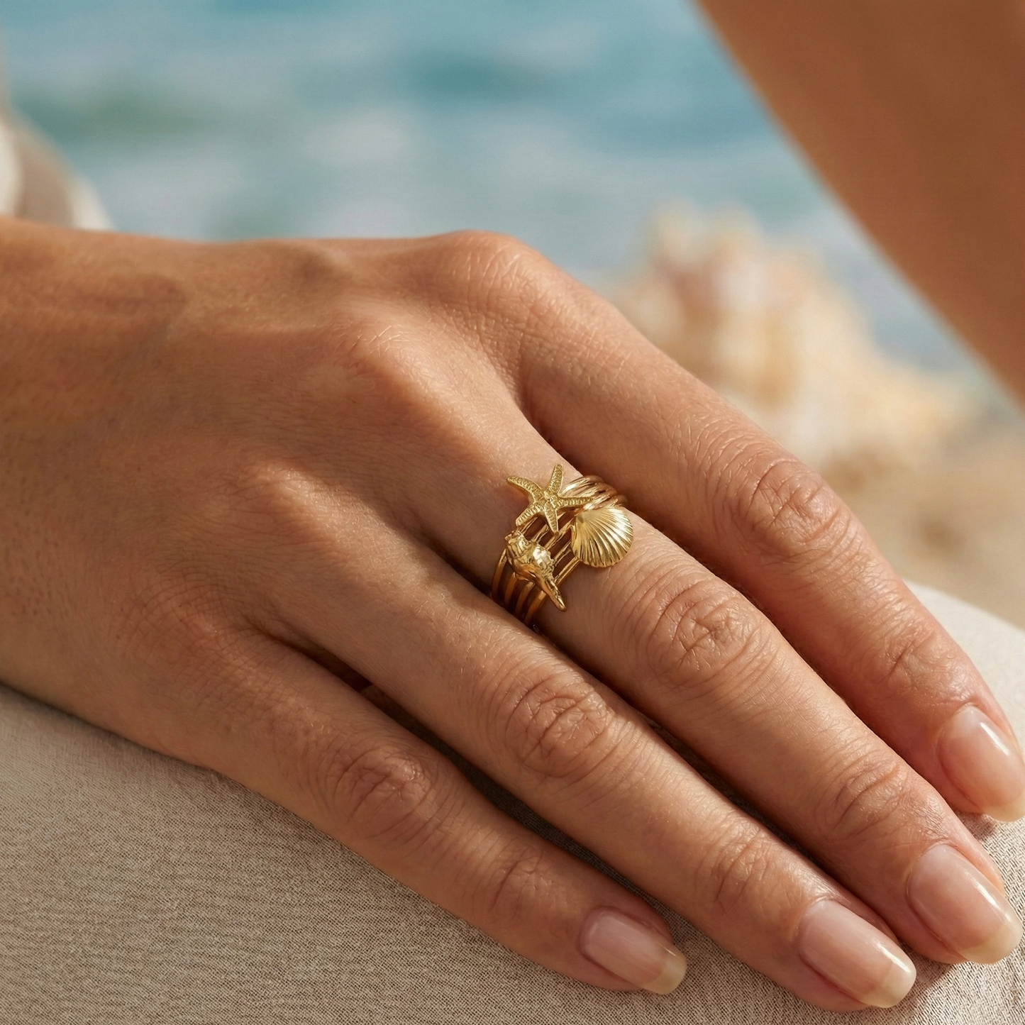 Bague large multi-rangs illusion accumulation : motifs étoile de mer et coquillages en acier inoxydable doré.