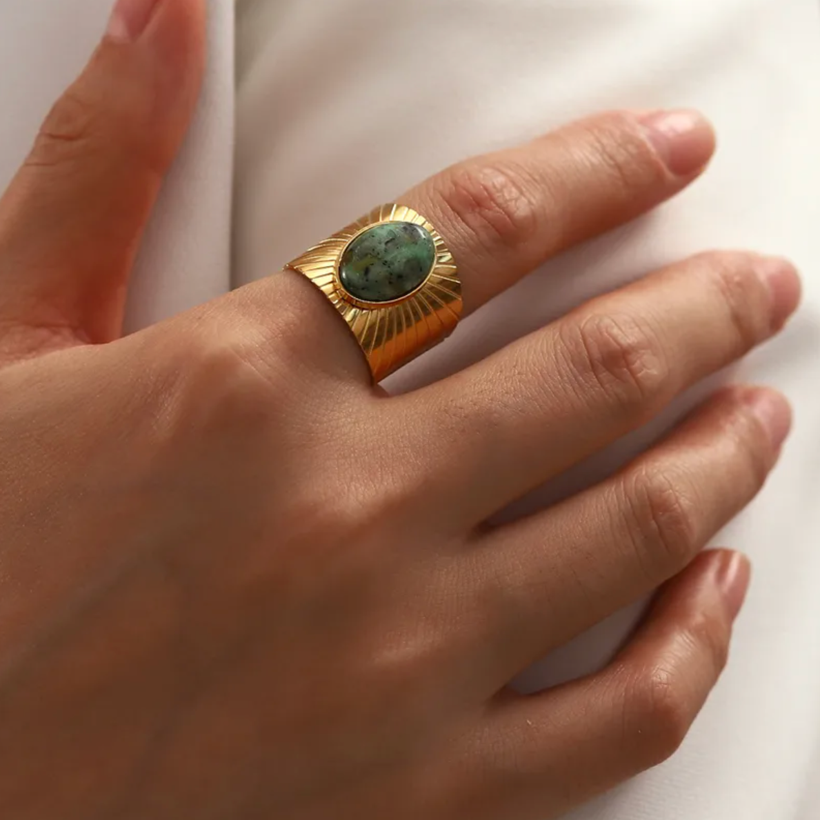 Cette bague large en acier inoxydable doré, sertie d’une pierre verte ovale, offre un style affirmé et une forte présence visuelle. Inspirée des bijoux ethniques et solaires, elle attire par ses volumes et ses reflets naturels.

Matériau : Acier inoxydable couleur doré, placage PVD or 18K, pierre synthétique effet malachite ou jaspe, hypoallergénique, résistant à l’eau et à l’oxydation.

Dimensions : Pierre 1,9 cm, anneau large – taille ajustable – poids 6,4 g.

Design : Structure épaisse gravée de rayons a