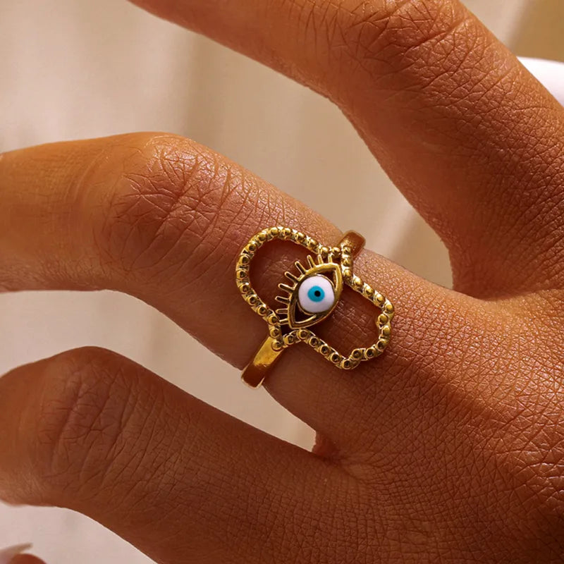 Portez la protection ancestrale de la main de Fatma avec cette bague dorée en acier inoxydable, ornée d’un œil bleu central inspiré de l’œil de Nazar. Ce bijou aux lignes épurées et au symbolisme fort est parfait pour un style à la fois spirituel et tendance.