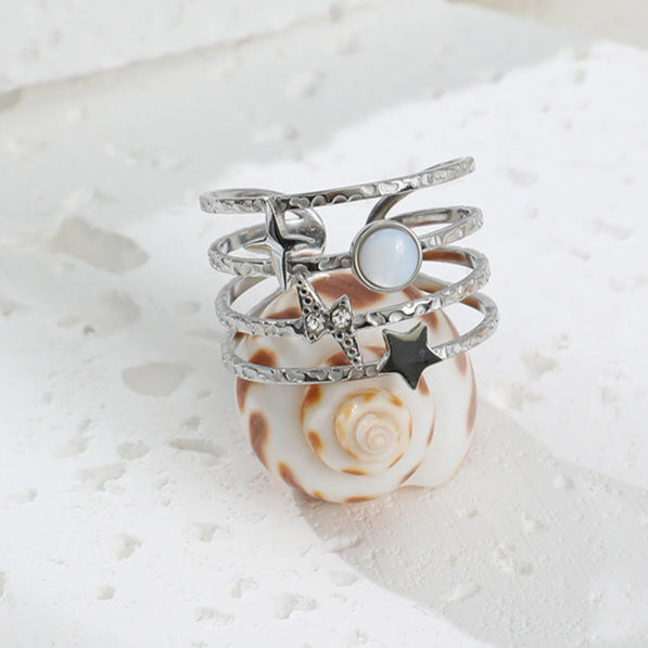 Ajoutez une touche céleste à votre style avec cette bague manchette au design astral. Conçue en acier inoxydable doré, cette pièce unique arbore une étoile à 4 branches, un éclair incrusté de strass, un disque nacré et une étoile filante. L’ensemble repose sur une base martelée à plusieurs anneaux, apportant une texture raffinée et une structure moderne.

Matériau : Acier inoxydable – résistant à l’eau et à l’oxydation.
