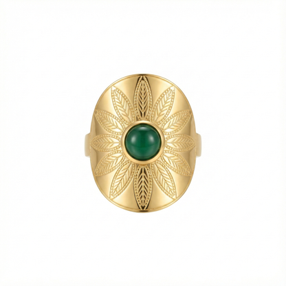 Bague manchette large en acier inoxydable doré, gravée de motifs feuilles avec une pierre verte centrale ovale.