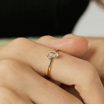 Bague marquise dorée or 18k avec pierre centrale scintillante et entourage de zircons blancs, design fin et élégant