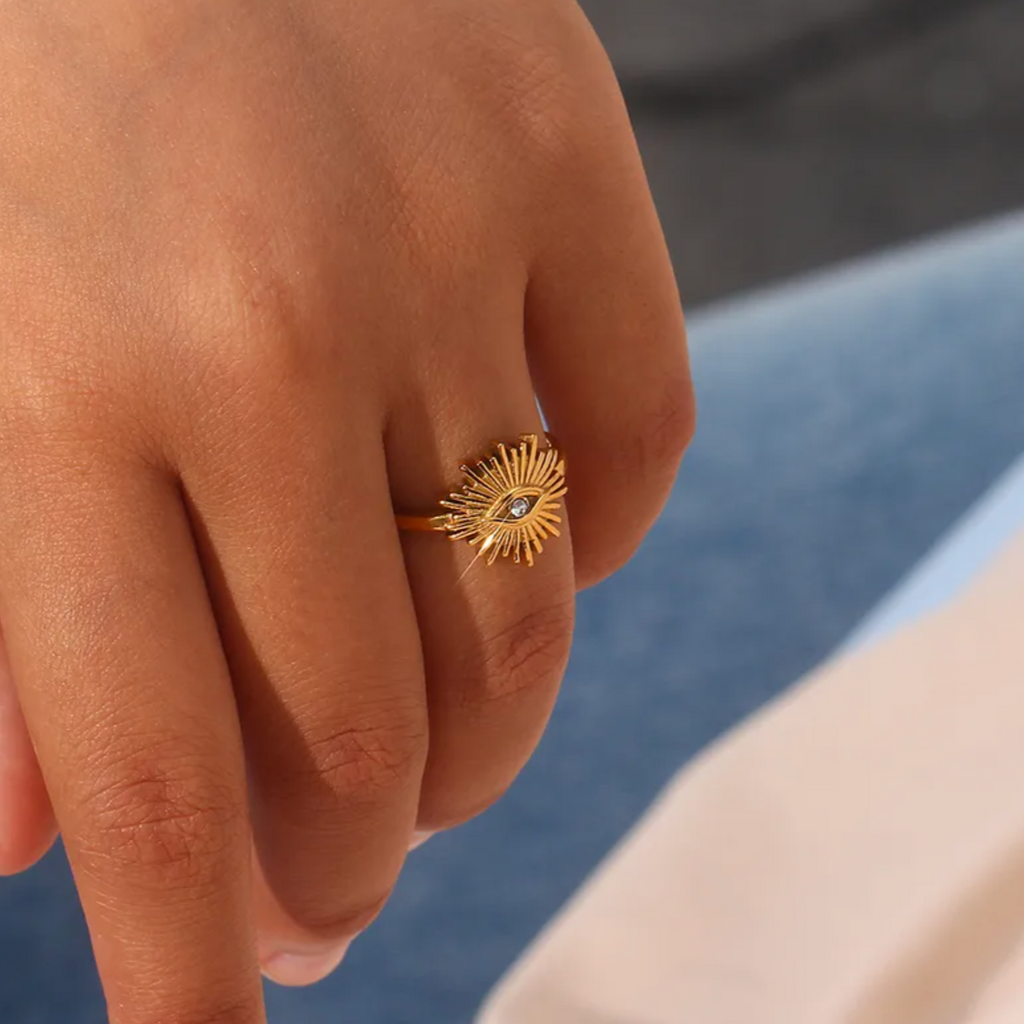 Cette bague en acier inoxydable doré, ornée d’un œil central rayonnant incrusté d’un petit cristal, est un symbole de protection, de vigilance et de spiritualité. Avec son design solaire et sa finition brillante, elle attire l’attention avec élégance.

Matériau : Acier inoxydable couleur doré, placage PVD or 18K, cristal central, hypoallergénique, résistant à l’eau et à l’oxydation.

Dimensions : Motif 1,3 cm, largeur anneau 0,2 cm, taille ajustable, poids 3,5 g.