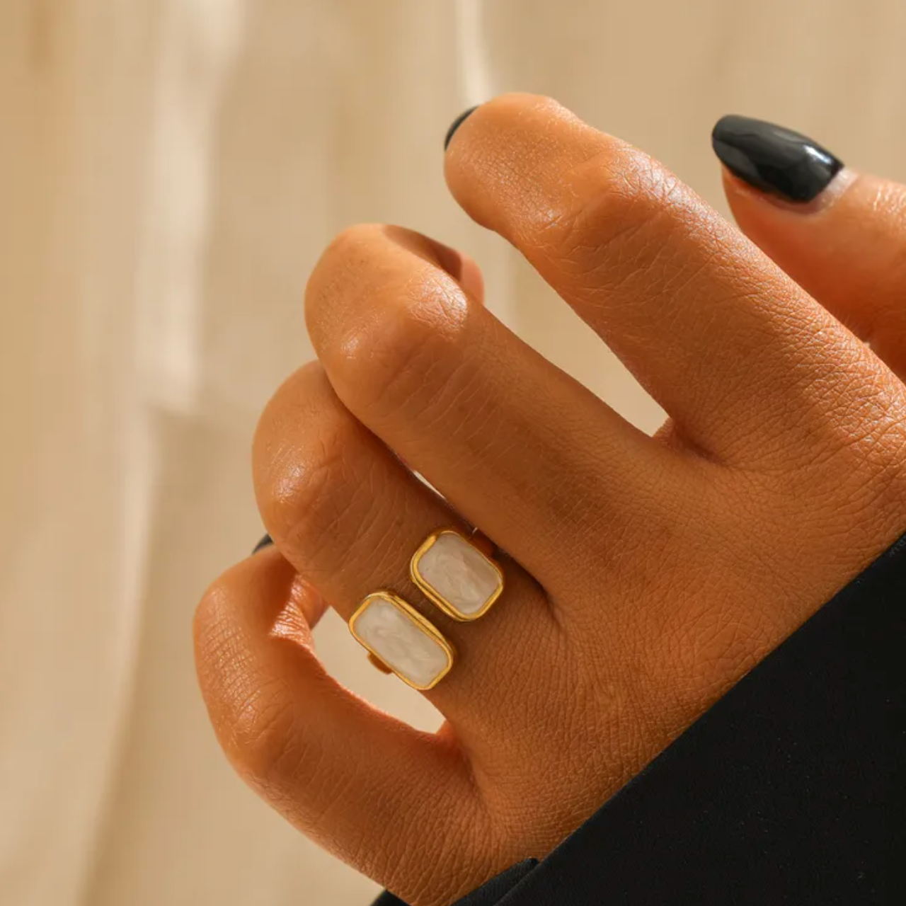 Une bague tendance et graphique, dotée de deux rectangles en émail blanc marbré, montés face à face sur une base ouverte. Une pièce contemporaine, à l’allure minimaliste mais impactante.

Matériau : Acier inoxydable couleur doré, émail blanc nacré, résistant à l’eau, hypoallergénique.

Dimensions : Largeur 1,8 cm – ajustable – poids 2,7 g.

Design : Deux formes rectangulaires légèrement bombées, aux reflets nacrés, fixées sur un anneau ouvert rigide. Finition dorée lisse et brillante.

Style : À porter seul