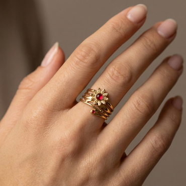 Bague solaire en acier inoxydable doré avec motif fleur rayonnante et pierres rouges, bijou symbolique et audacieux