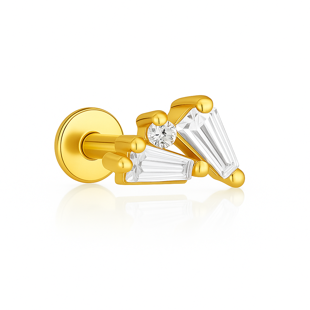 Boucle d’oreille en argent 925 doré à l’or fin, jouant avec l’asymétrie et la lumière. Deux zircons taillés en trapèze s’entrelacent en diagonale, rehaussés d’un petit zircon rond central. Le tout est sublimé par des embouts billes dorés, pour un rendu structuré et élégant.

Ce bijou crée un effet visuel original et raffiné, parfait pour sublimer un lobe avec une touche d’éclat maîtrisée.

Matériaux : Argent 925 doré à l’or fin, zircons baguette et rond
Type : Boucle d’oreille clou, à vis
Style : Création g
