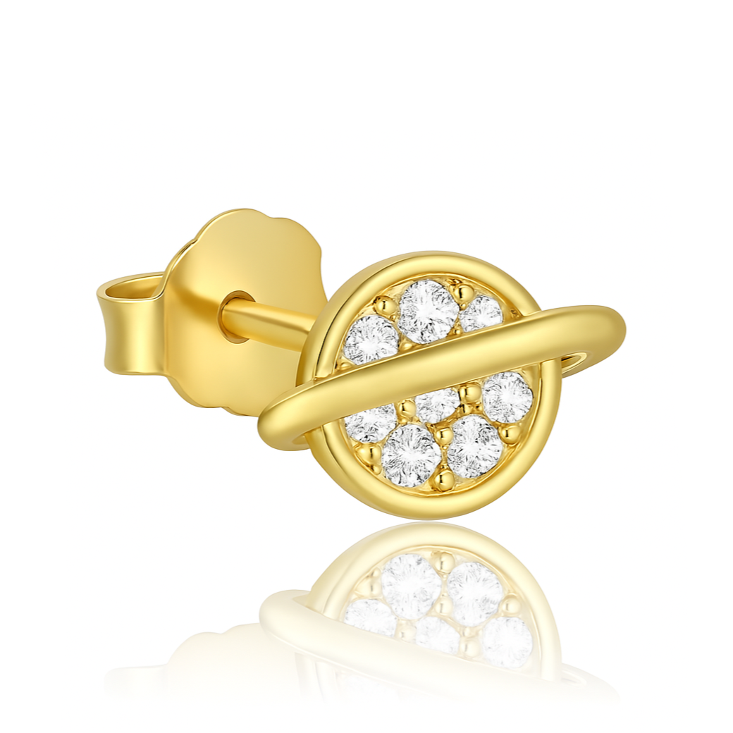 Ajoutez une touche cosmique et scintillante à votre look avec cette boucle d’oreille unique en argent 925 doré à l’or fin, représentant une miniature de la planète Saturne finement travaillée. Son diamètre discret de 0,45 cm en fait un bijou délicat, facile à porter au quotidien tout en affirmant un style céleste. Le cœur de la planète est serti de zircons brillants qui captent la lumière à chaque mouvement, tandis que l’anneau de Saturne, en argent doré à l’or fin, apporte une finition précieuse et subtile