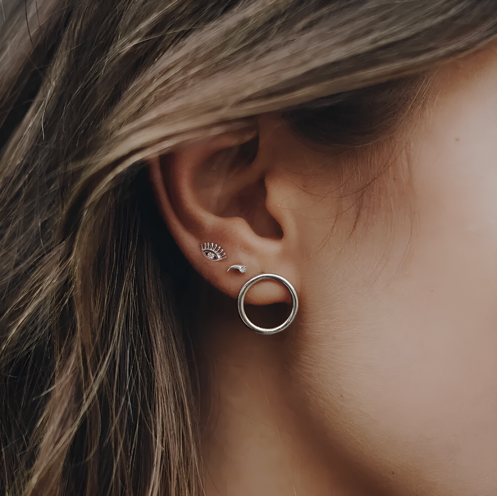 Apportez une touche de mystère et de protection à votre style avec ces boucles d'oreilles puces en argent 925, ornées d’un œil symbolique et d’un zircon étincelant. L'œil, représentant la protection et la sagesse, mesure 0,6 cm, tout en mettant en avant un design raffiné et moderne. L'argent 925 assure une brillance durable, tandis que le zircon ajoute un éclat subtil et lumineux.