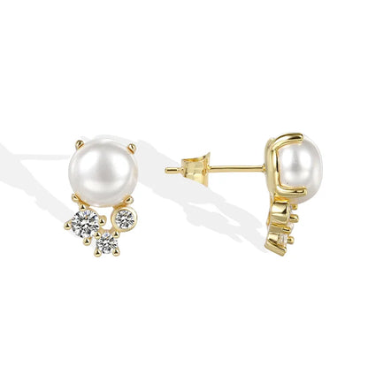 Boucles d’oreilles clous dorées pour femme en plaqué or, ornées d’une perle blanche synthétique et de trois zircons étincelants. Bijou élégant et raffiné, au style classique revisité, parfait pour sublimer le visage avec éclat et douceur