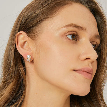 Boucles d’oreilles clous dorées pour femme en plaqué or, ornées d’une perle blanche synthétique et de trois zircons étincelants. Bijou élégant et raffiné, au style classique revisité, parfait pour sublimer le visage avec éclat et douceur