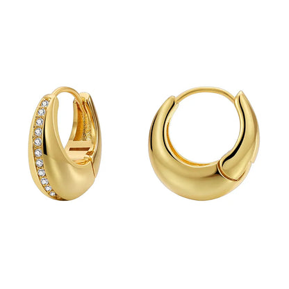 Boucles d’oreilles créoles bombées dorées pour femme en plaqué or, ornées d’une ligne de strass délicats sur une face. Bijou chic et moderne au design sculptural et brillant, idéal pour un look élégant, urbain et raffiné