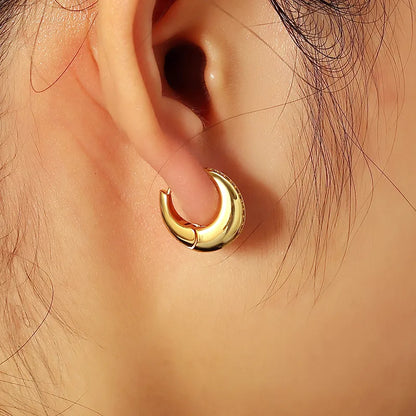 Boucles d’oreilles créoles bombées dorées pour femme en plaqué or, ornées d’une ligne de strass délicats sur une face. Bijou chic et moderne au design sculptural et brillant, idéal pour un look élégant, urbain et raffiné