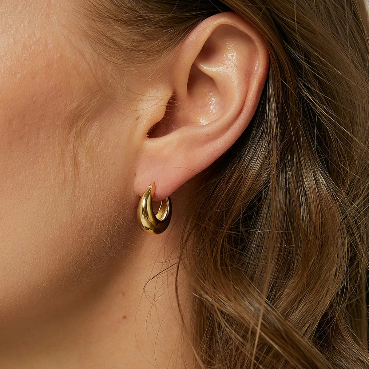 Boucles d’oreilles créoles bombées dorées pour femme en plaqué or, au fini miroir brillant et à la forme arrondie épaisse. Bijou minimaliste et chic, léger et confortable, idéal pour un style moderne, épuré et intemporel au quotidien