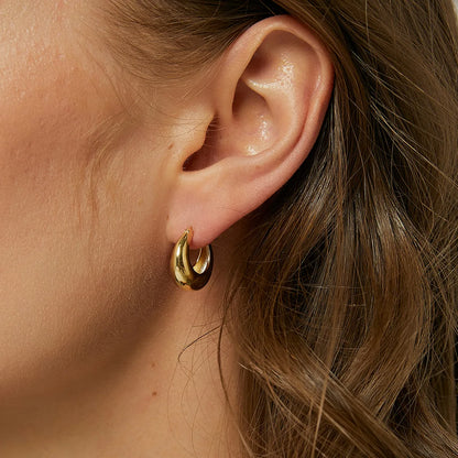 Boucles d’oreilles créoles bombées dorées pour femme en plaqué or, au fini miroir brillant et à la forme arrondie épaisse. Bijou minimaliste et chic, léger et confortable, idéal pour un style moderne, épuré et intemporel au quotidien