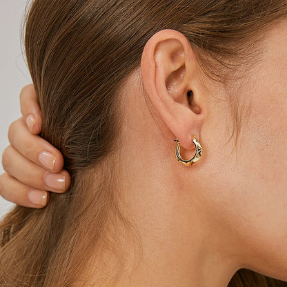 Boucles d’oreilles créoles dorées pour femme en plaqué or, au design géométrique facetté et angulaire. Bijou moderne et architectural au style minimaliste et raffiné, léger et confortable, parfait pour une allure urbaine et contemporaine