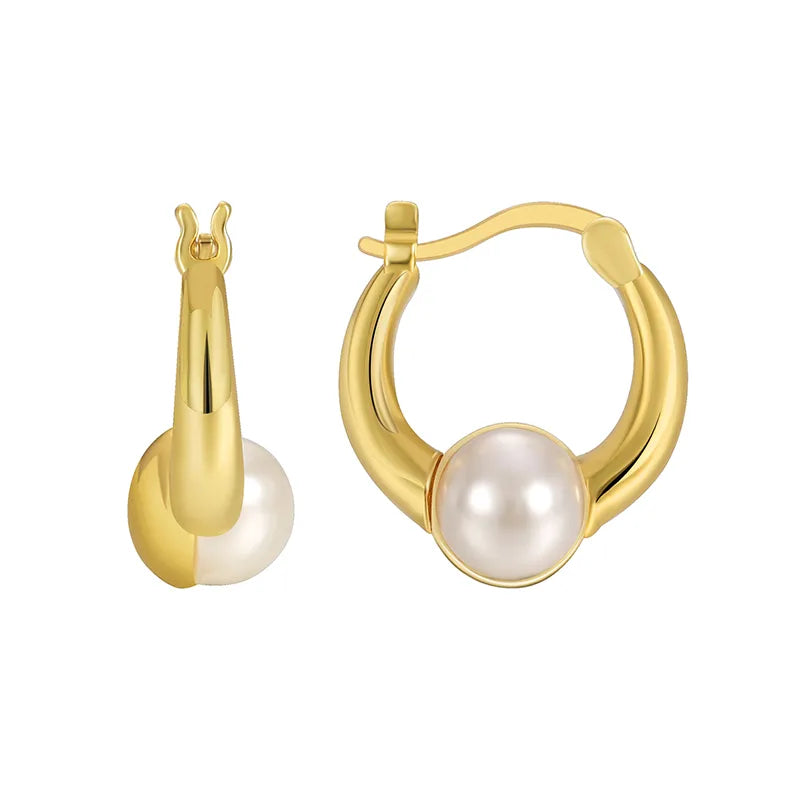 Boucles d’oreilles créoles dorées pour femme en plaqué or, ornées d’une perle blanche suspendue au centre de l’anneau. Bijou chic et féminin au style classique et contemporain, lumineux et raffiné, parfait pour une tenue élégante ou de soirée.