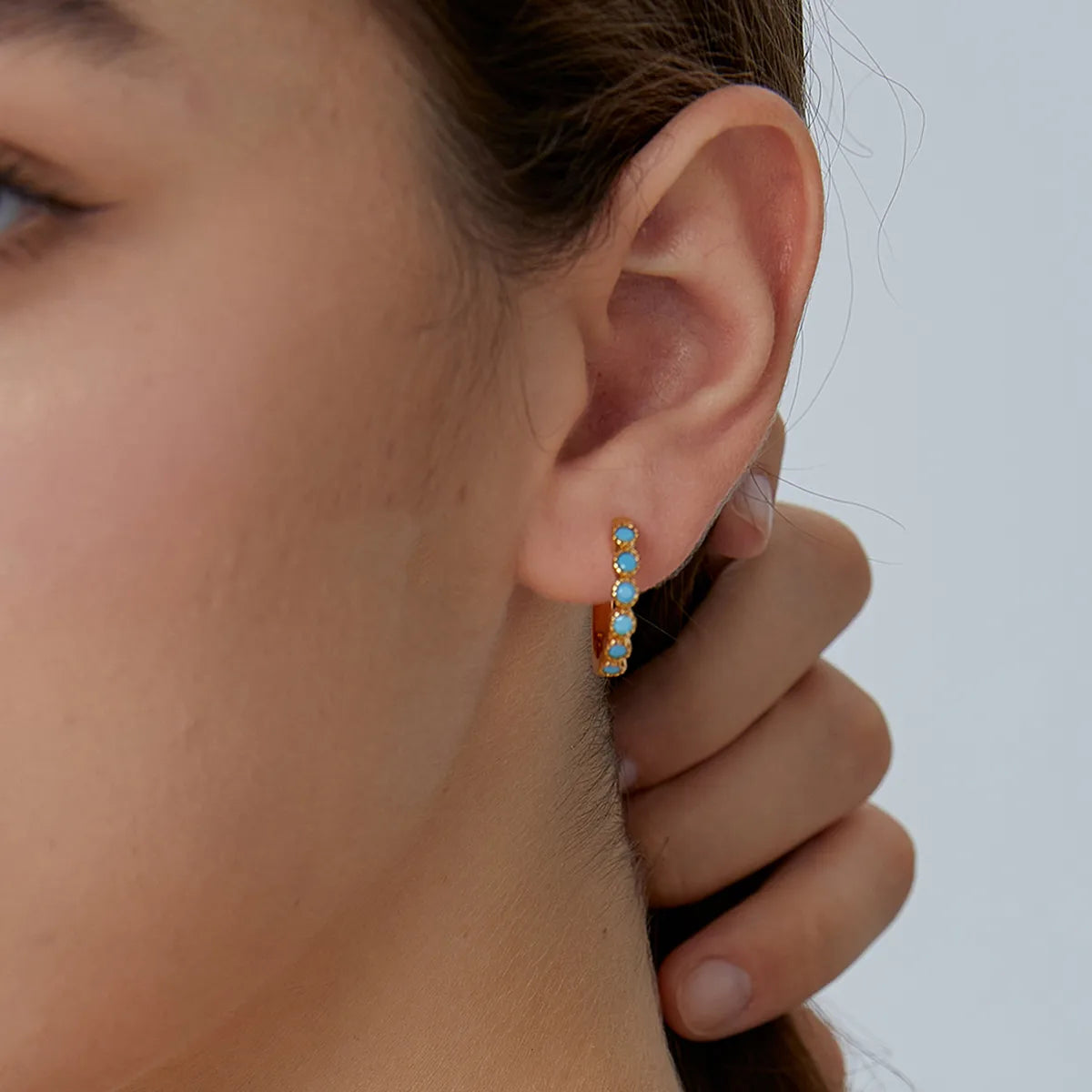 Boucles d’oreilles créoles dorées pour femme en plaqué or, ornées de pierres turquoise rondes et de détails perlés sertis. Bijou lumineux et estival au style bohème chic, parfait pour illuminer une tenue du quotidien ou une escapade en bord de mer.