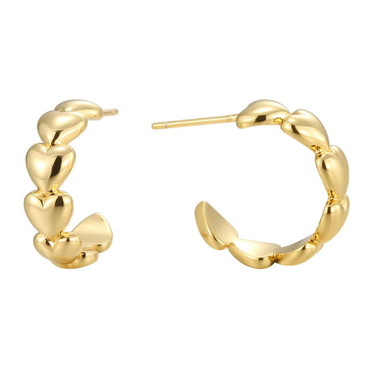 Boucles d’oreilles créoles dorées pour femme en plaqué or, en forme de cœurs bombés successifs au fini poli brillant. Bijou romantique et tendance au style féminin et lumineux, parfait pour un look élégant ou un cadeau symbolique