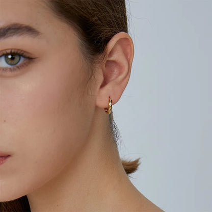 Boucles d’oreilles créoles dorées pour femme en plaqué or, au design facetté angulaire incrusté de strass brillants. Bijou moderne et graphique au style chic et minimaliste, léger et lumineux, parfait pour un look structuré et élégant