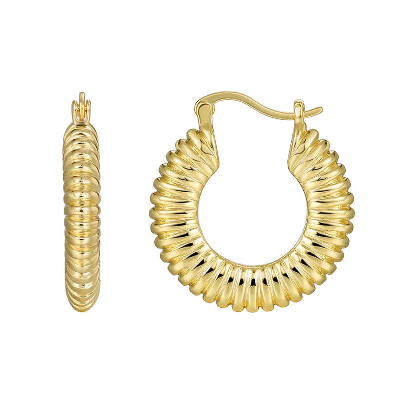 Boucles d’oreilles créoles dorées pour femme en plaqué or, à texture ondulée et finition brillante. Bijou statement inspiré des années 80, au style rétro-chic et glamour, parfait pour sublimer une tenue sobre ou un look moderne audacieux