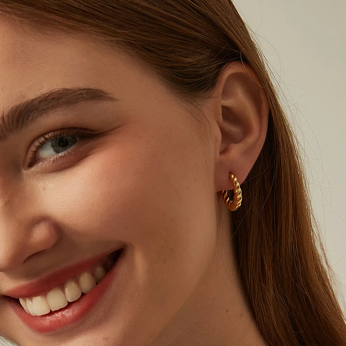 Boucles d’oreilles créoles dorées pour femme en plaqué or, au design torsadé épais et sculptural. Bijou lumineux et audacieux au style chic et moderne, léger et confortable, parfait pour une tenue élégante de jour ou de soirée