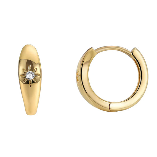 Boucles d’oreilles créoles dorées pour femme en plaqué or, inspirées de la symbolique céleste avec un zircon serti en étoile du nord à huit branches. Bijou élégant et lumineux au poli miroir, léger et raffiné, parfait pour un style solaire et minimaliste