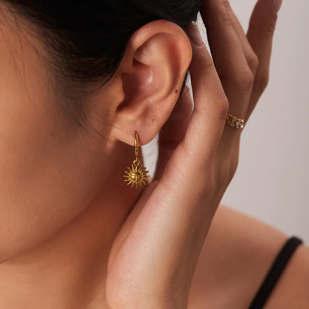Boucles d’oreilles créoles dorées en acier inoxydable avec pendentif soleil rayonnant, bijou bohème chic symbolisant la lumière et la vitalité. Résistantes à l’eau et hypoallergéniques, parfaites pour un style solaire et féminin