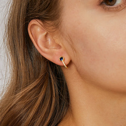 Boucles d’oreilles demi-créoles dorées pour femme en plaqué or, ornées d’un zircon bleu intense et de zircons blancs étincelants sur la courbe inférieure. Bijou chic et contemporain, raffiné et lumineux, parfait pour un look élégant au quotidien ou en soirée