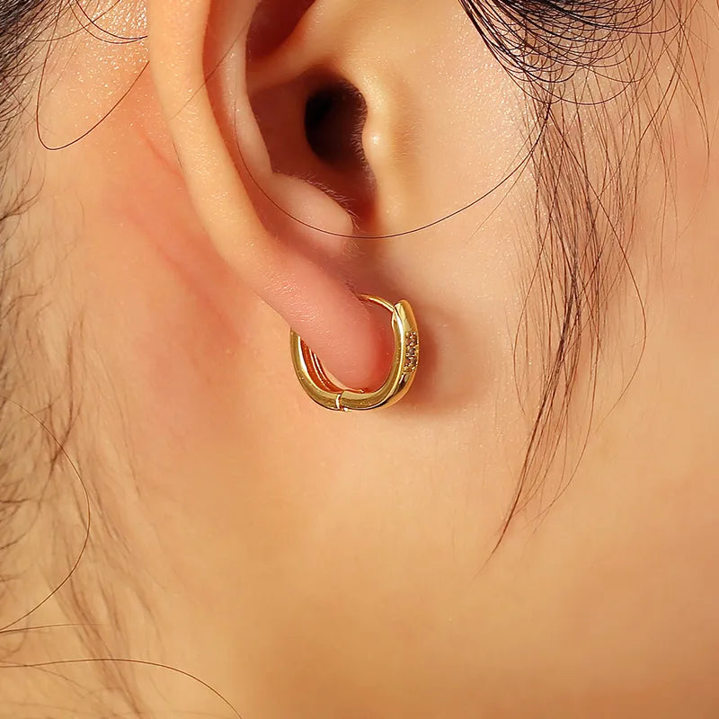 Boucles d’oreilles mini créoles dorées pour femme en plaqué or, serties d’un pavé de zircons cubiques scintillants. Bijou chic, discret et raffiné, au style minimaliste et intemporel, idéal pour un look élégant de jour comme de nuit. Parfaites pour offrir ou compléter une tenue sophistiquée avec des bijoux dorés modernes.