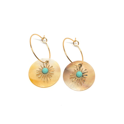 Boucles d’oreilles pendantes dorées en acier inoxydable, disque en nacre naturelle décoré d’un motif soleil et d’un centre turquoise. Bijou bohème chic et lumineux, hypoallergénique et résistant à l’eau