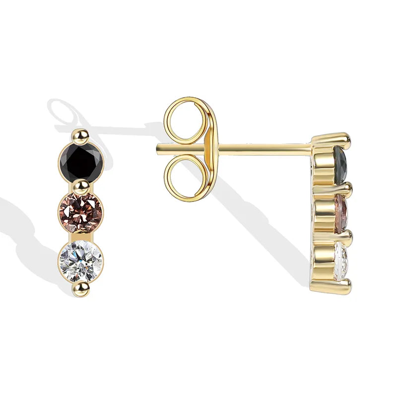 Boucles d’oreilles puces dorées pour femme en plaqué or, ornées de trois pierres alignées en dégradé noir, cognac et blanc. Bijou minimaliste et raffiné au design graphique, parfait pour un port quotidien discret ou un look élégant et coloré.