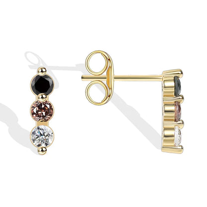Boucles d’oreilles puces dorées pour femme en plaqué or, ornées de trois pierres alignées en dégradé noir, cognac et blanc. Bijou minimaliste et raffiné au design graphique, parfait pour un port quotidien discret ou un look élégant et coloré.