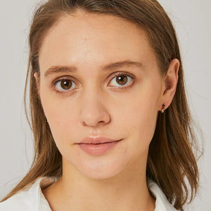 Boucles d’oreilles puces dorées pour femme en plaqué or, ornées de trois pierres alignées en dégradé noir, cognac et blanc. Bijou minimaliste et raffiné au design graphique, parfait pour un port quotidien discret ou un look élégant et coloré.