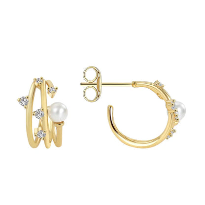 Boucles d’oreilles puces dorées pour femme en plaqué or, composées de deux anneaux entrelacés ornés de zircons scintillants et d’une perle blanche ronde. Bijou chic et raffiné, au design moderne et féminin, idéal pour une tenue habillée ou élégante au quotidien