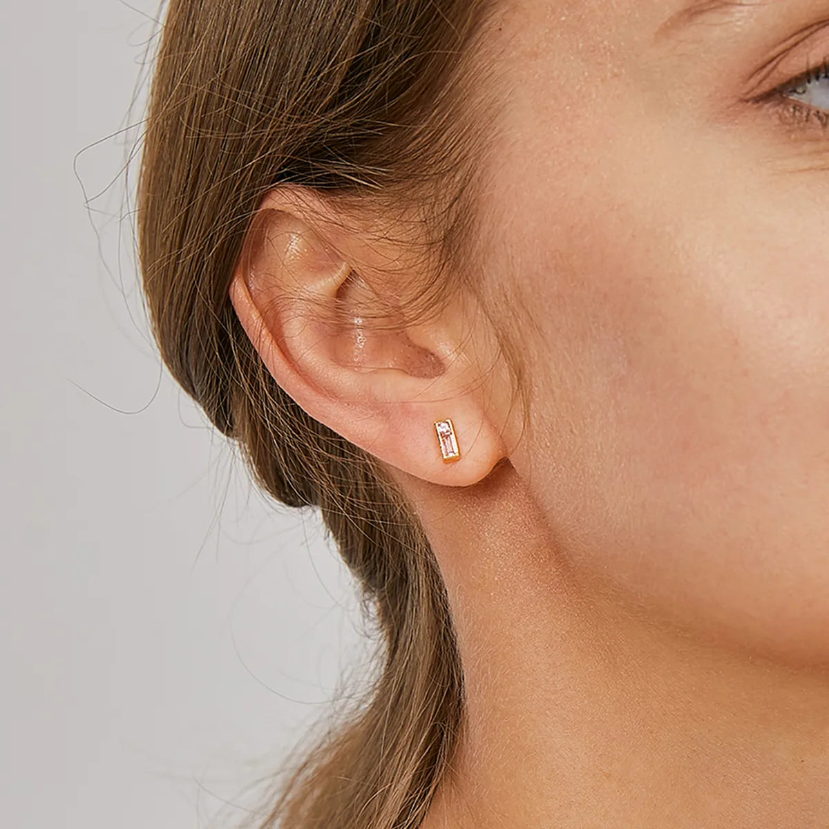 Boucles d’oreilles puces dorées rectangulaires pour femme en plaqué or, ornées de zircons roses taille baguette et brillant. Bijou féminin et délicat au design minimaliste, lumineux et raffiné, parfait pour un look élégant ou un cadeau chic