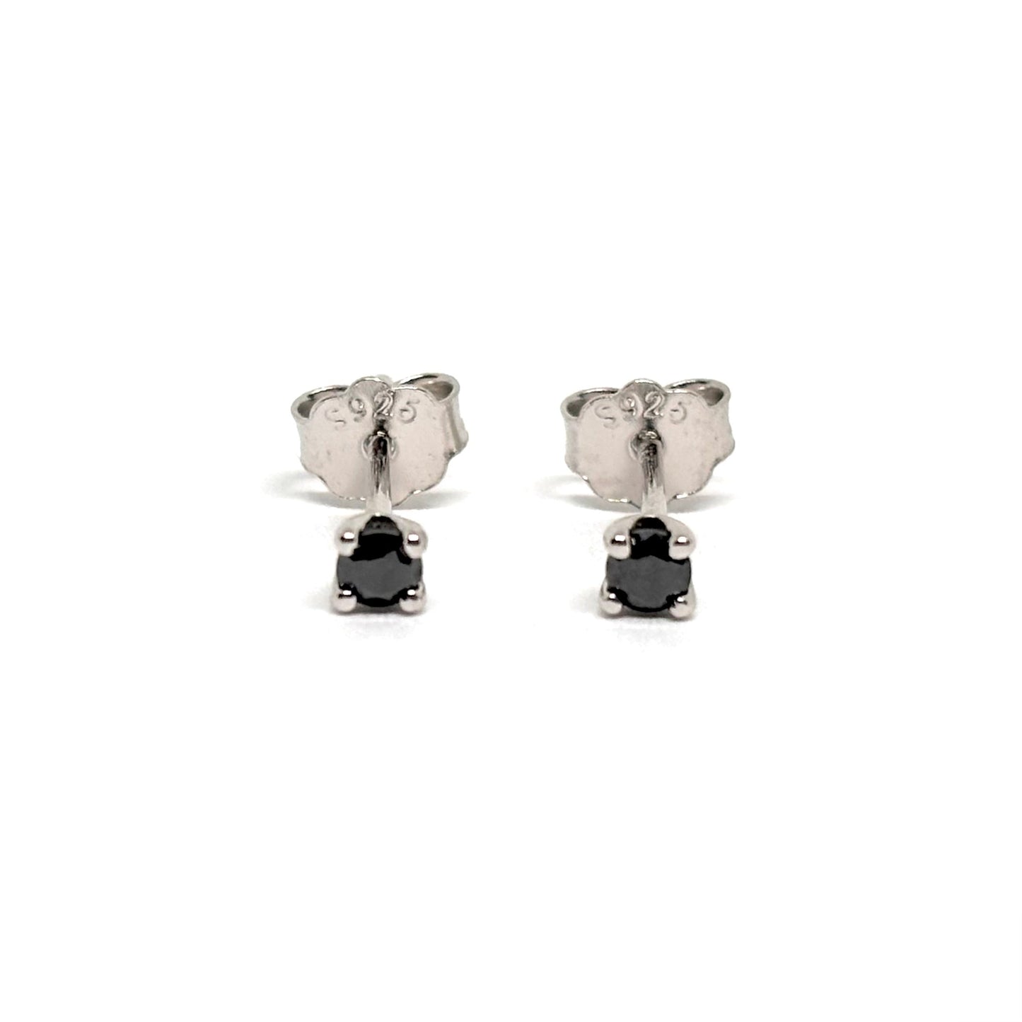 Boucles d’oreilles puces en argent 925 serties de pierres noires facettées. Bijou minimaliste et intemporel, mixte, hypoallergénique et résistant au ternissement.