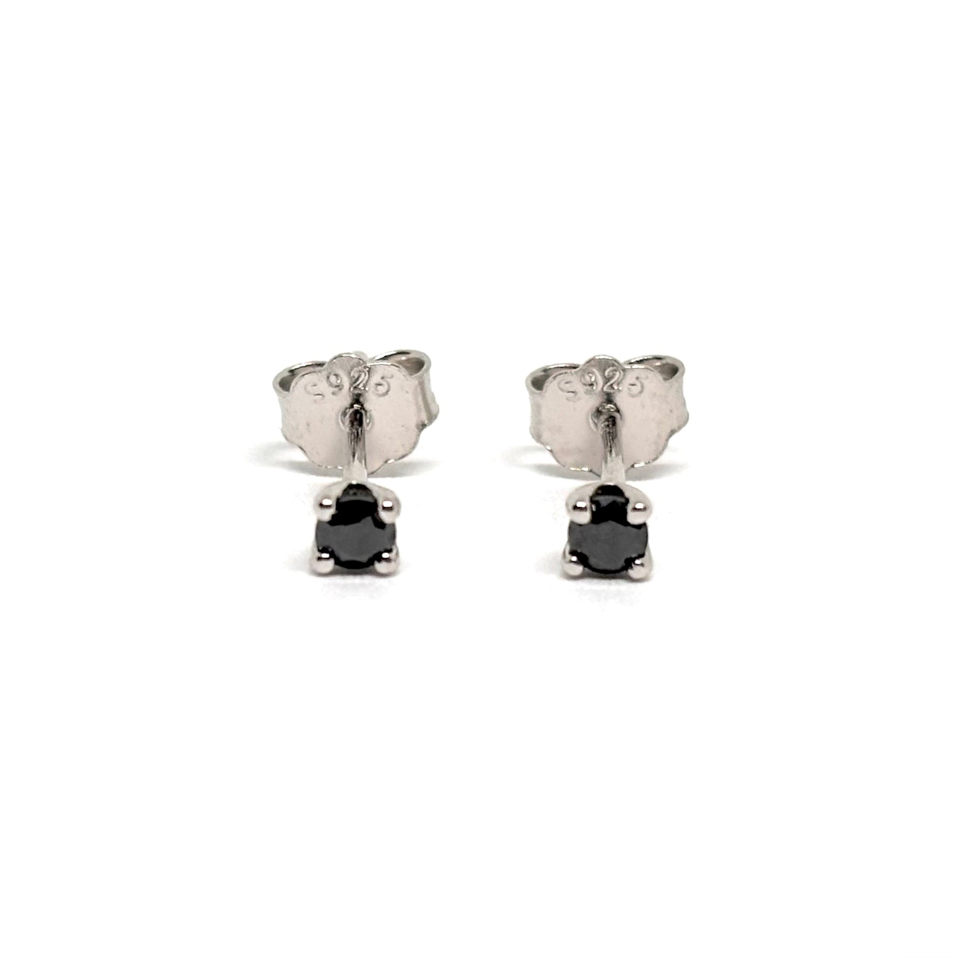 Boucles d’oreilles puces en argent 925 serties de pierres noires facettées. Bijou minimaliste et intemporel, mixte, hypoallergénique et résistant au ternissement.