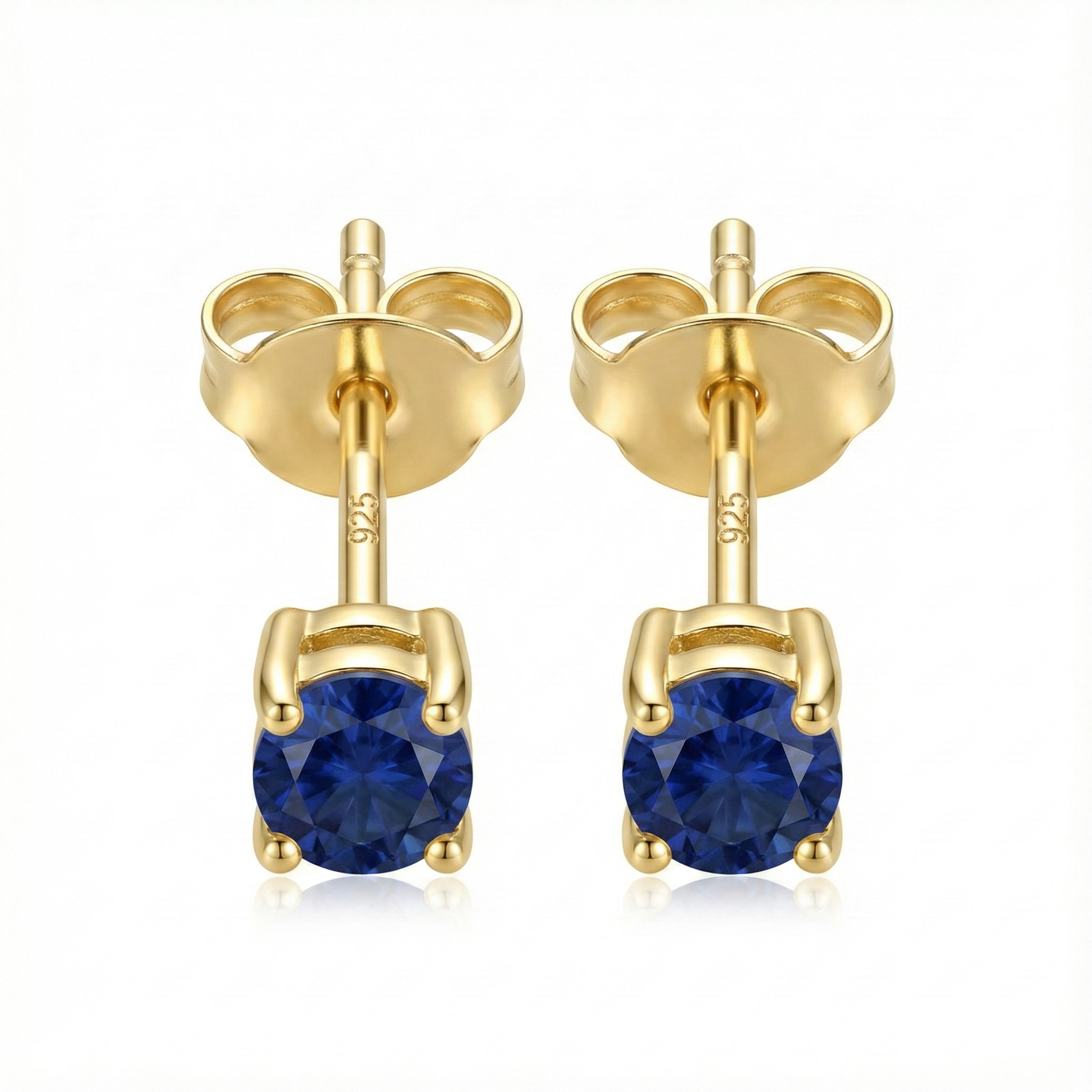 Boucles d'oreilles puces en argent doré avec pierre zircon couleur saphir bleu roi, style joaillerie élégant.