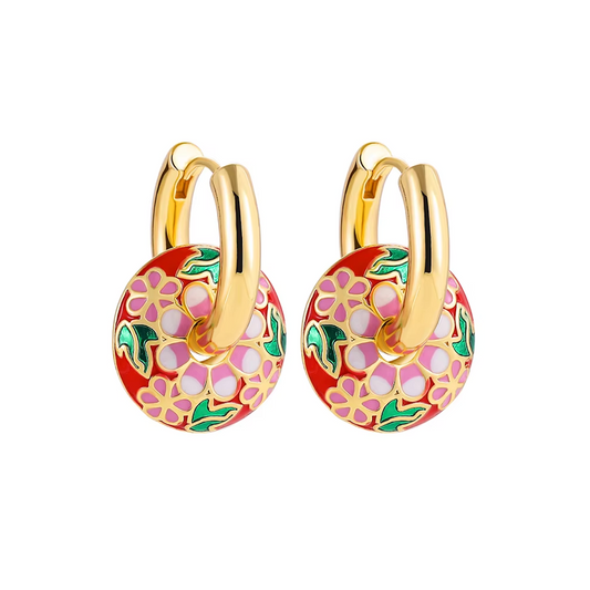 Boucles d’oreilles créoles couleur or avec pendentif rond émaillé motif floral multicolore.