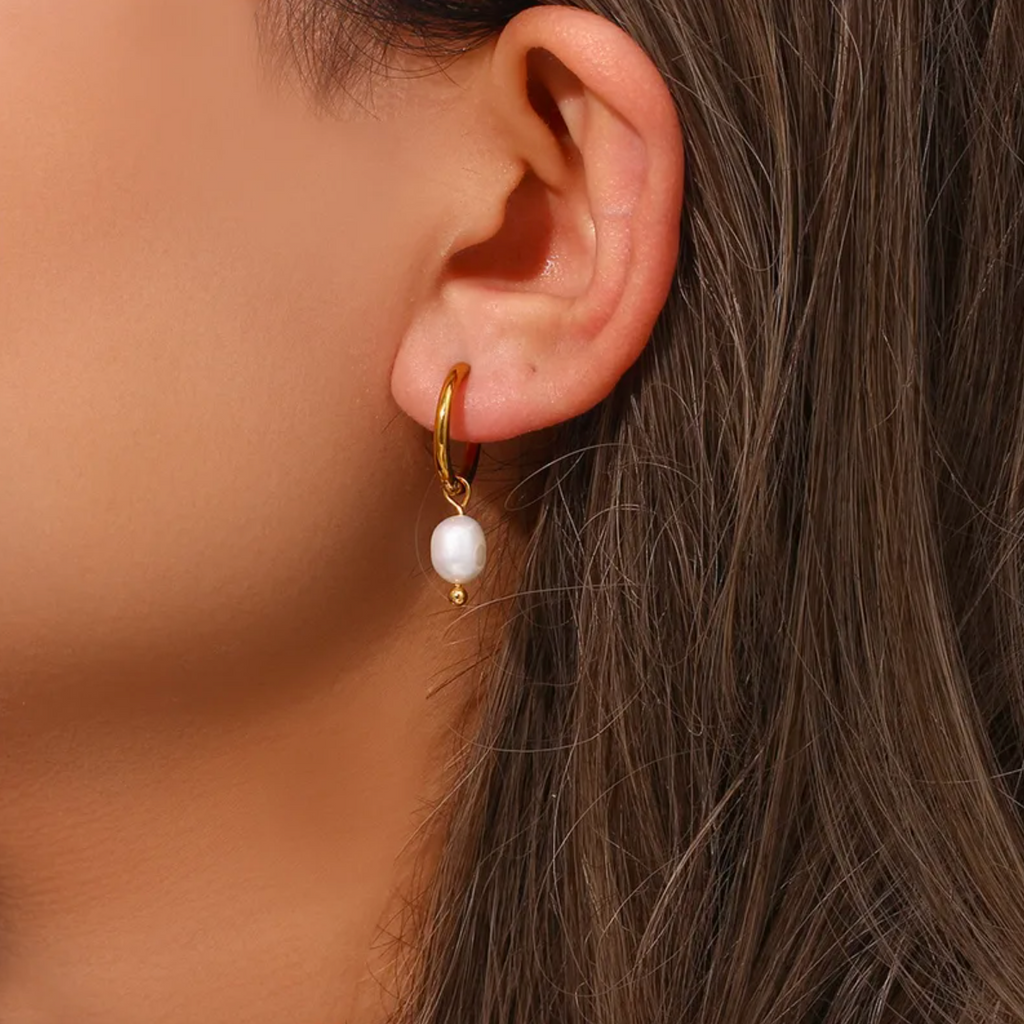 Des créoles pendantes en acier inoxydable doré, rehaussées de perles blanches en goutte, pour une allure à la fois minimaliste, chic et féminine. L’équilibre parfait entre modernité et douceur intemporelle.

Type : Boucles d’oreilles pendantes – créoles.
Matériau : Acier inoxydable couleur doré, perles synthétiques blanches, hypoallergénique, résistant à l’eau et à l’oxydation.

Dimensions : Longueur totale 2,9 cm, perle 1,6 cm, poids 4 g la paire.

Design : Anneaux ronds dorés d’où pend une perle blanche o