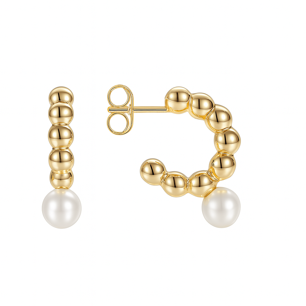 Ces boucles d’oreilles dorées en demi-créoles se distinguent par leur design sculptural, composé d’une succession de perles métalliques formant un arc délicat. Une perle blanche nacrée suspendue à l’extrémité apporte une touche de douceur, contrastant élégamment avec le métal poli.

Leur silhouette moderne et féminine revisite la créole classique avec une dimension contemporaine et raffinée. L’alternance de reliefs et de brillances capte subtilement la lumière, créant un jeu de textures délicat.