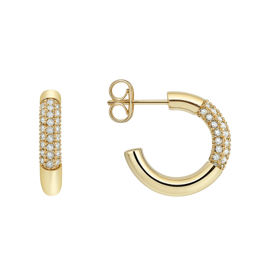 Ces boucles d’oreilles créoles dorées en forme de cercle semi-ouvert se distinguent par leur design épuré et leur éclat raffiné. Une ligne de zircons ronds scintillants habille l’extérieur du bijou, apportant un reflet lumineux subtil à chaque mouvement. Le métal doré bombé contraste avec la finesse des pierres, créant une silhouette moderne et précieuse.