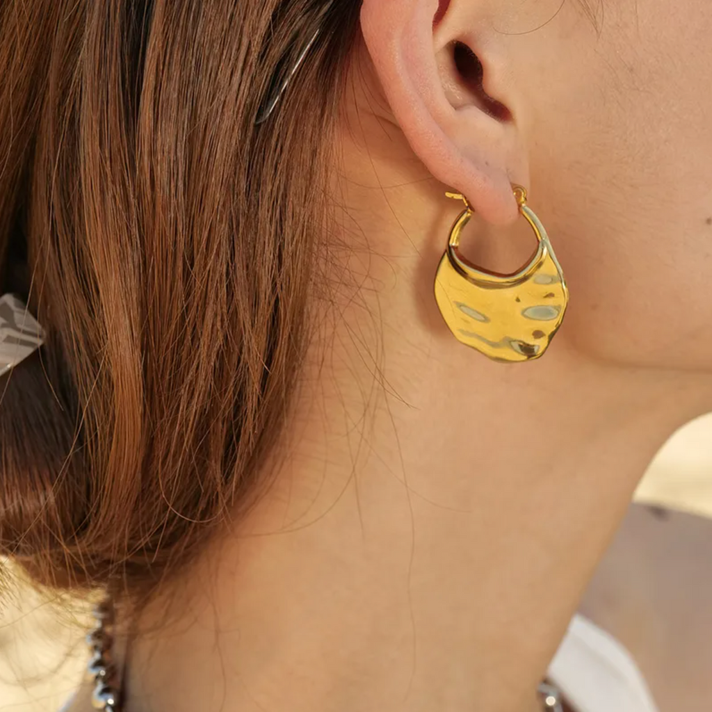 Des créoles larges à l’effet martelé, en acier inoxydable doré, pour un look sculptural et contemporain. Une pièce forte, lumineuse, au design organique et assumé.

Type : Boucles d’oreilles créoles pendantes.
Matériau : Acier inoxydable couleur doré, finition brillante, hypoallergénique, résistant à l’eau et à l’oxydation.