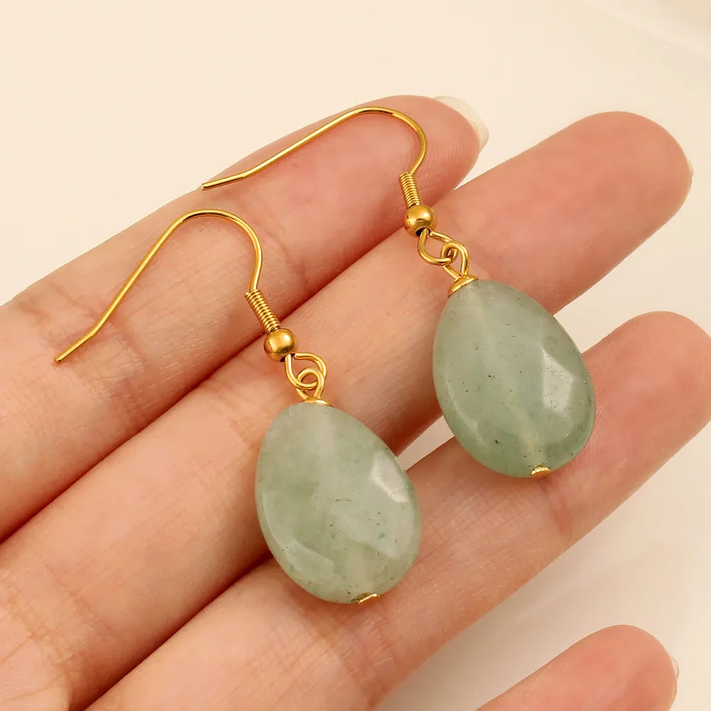Boucles d’oreilles pendantes couleur or en acier inoxydable avec pierre verte ovale, style élégant pour femme.