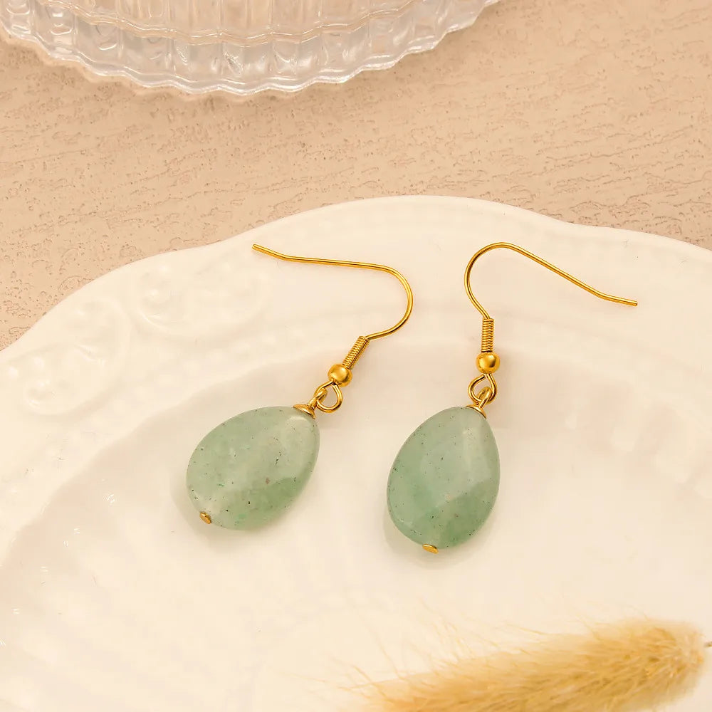 Boucles d’oreilles pendantes couleur or en acier inoxydable avec pierre verte ovale, style élégant pour femme.
